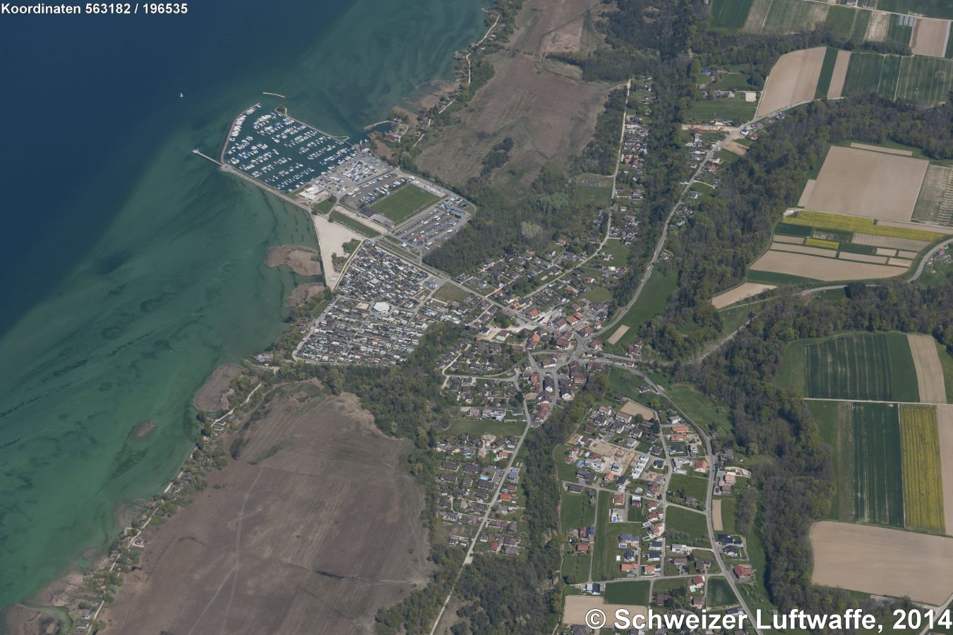 Portalban (Kanton Fribourg) am SE-Ufer des Neuenburgersees. Im Bildzentrum: Portalban-Dessous. In den See hinausreichend: Yachthafen, vorgelagert der Zeltplatz 'La Nacelle'. Gegen den untern rechten Bildrand: Portalban-Dessus.